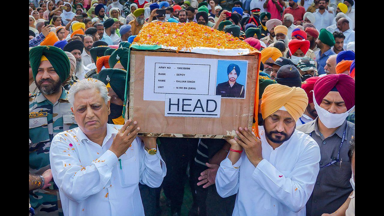Punjab Chief Minister Charanjit Singh Channi carries the mortal remains of martyr Sepoy Gajjan Singh during his funeral, at Pachranda village in Rupnagar district. Pic/PTI